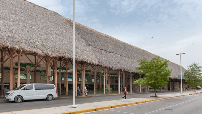 Aeropuerto de Punta Cana Terminales al aire libre del aeropuerto de Punta Cana con techos cubiertos de hojas de caña