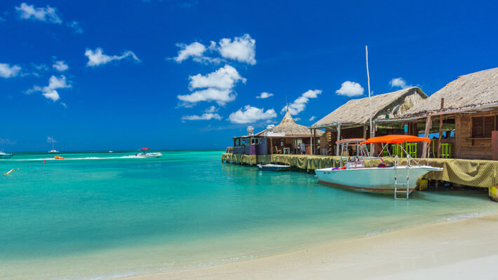 Playa de Palm, Aruba Playa de Palm con agua azul y arena blanca, a un costado se observa el muelle con un bote